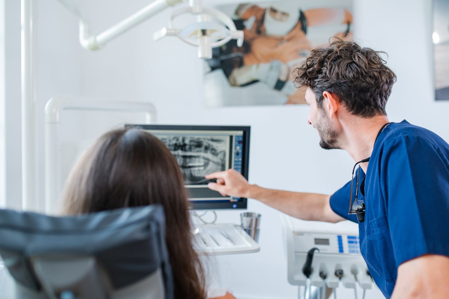 Zahnarzt und Patient am Roentgenbild